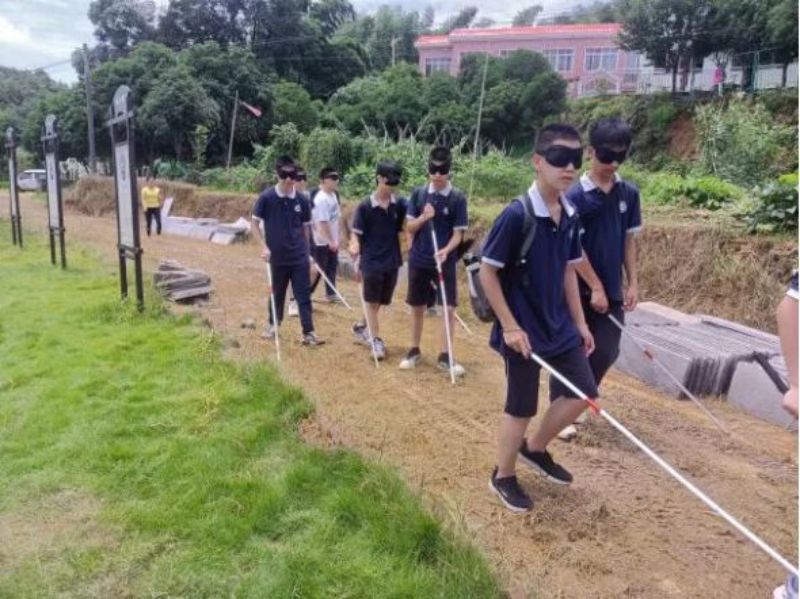 学生们在体验区体验盲人行走。.jpg