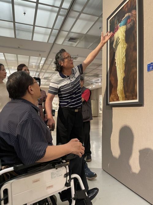 严荣宗向吕世明一行人介绍自己的油画作品。.jpg