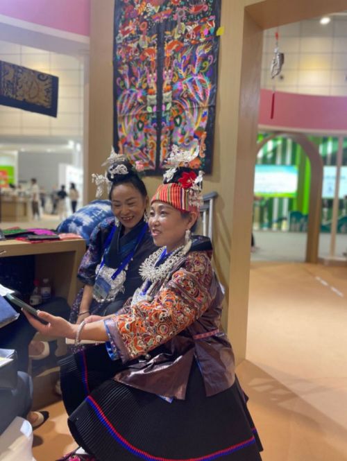 在“美丽工坊”贵州苗绣展示区，残疾绣娘张艳梅（左）在展示她的绣品。.jpg