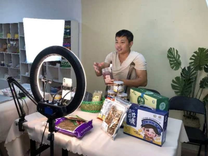欧阳天宪正在直播“带货”，展示农产品。.jpg