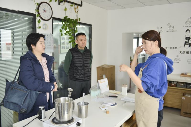 郑璇（左一）参观聋人创业公司时和聋人朋友交谈。.jpg