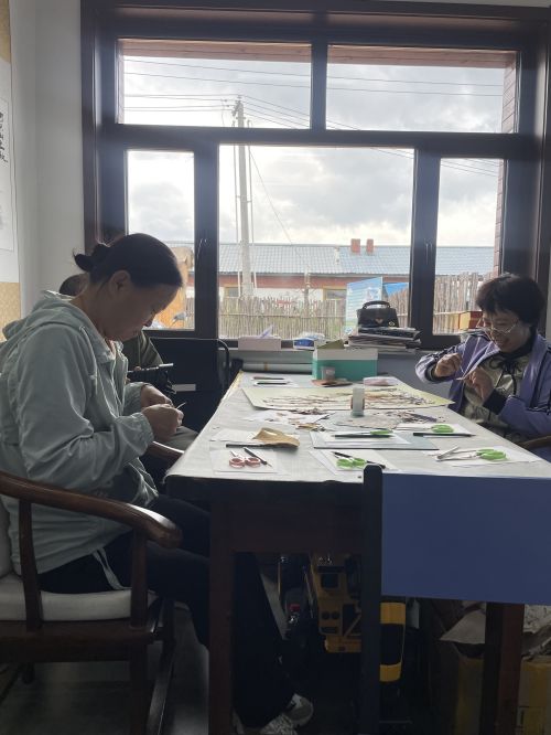 李淑英带领当地残疾人制作树皮画。.jpg
