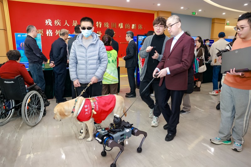 视障人士在首届汇爱科技展上体验电子导盲犬.jpg